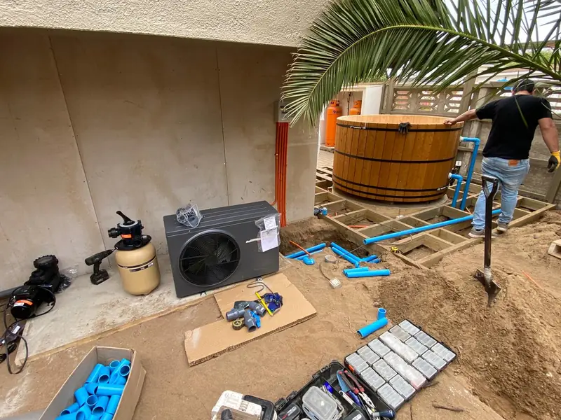 Instalación de bomba de calor junto a una tina de madera